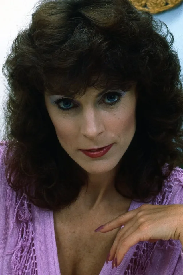 Kay Parker headshot, dark curly hair and purple top
