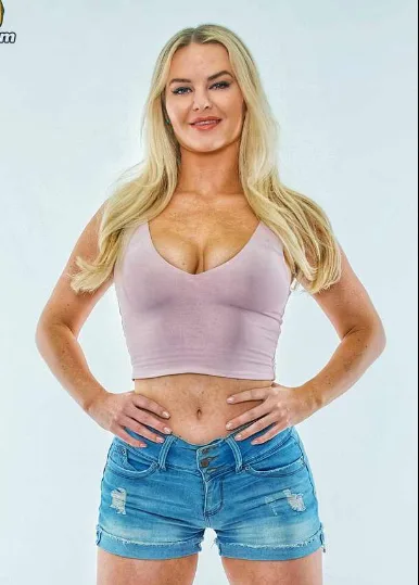 Slimthick Vic in a mauve crop top and denim shorts