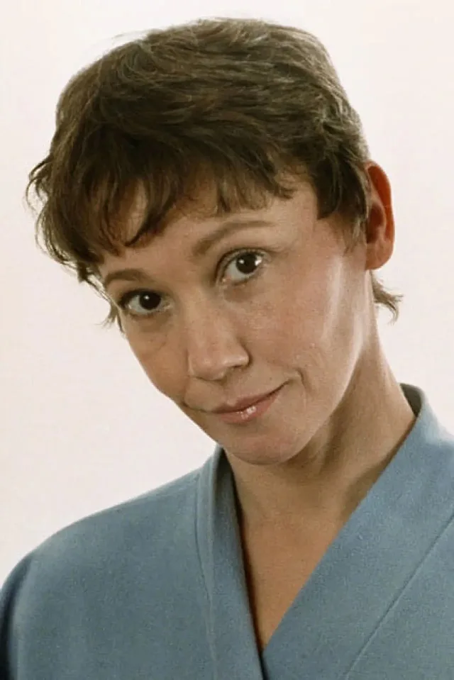 Georgina Spelvin headshot, short brown hair and blue top