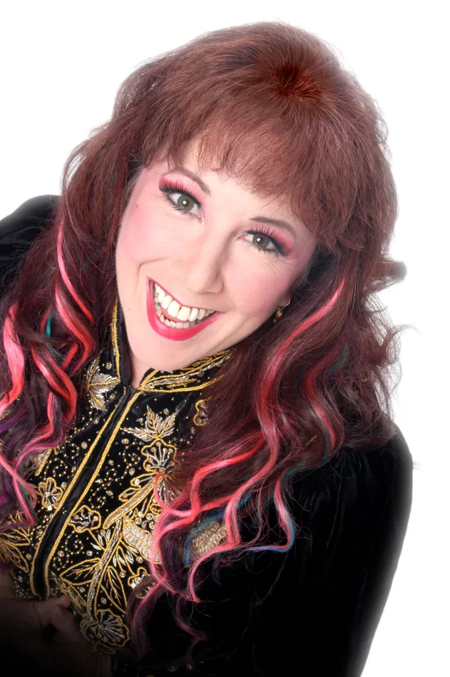 Annie Sprinkle studio headshot, embroidered black top